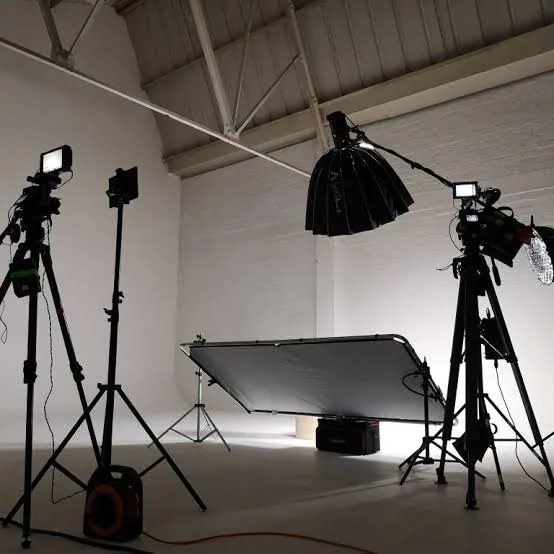 Studio produksi foto dan video Core Freelancers di kawasan Jiwo Perma, Surabaya Timur, dengan cyclorama putih, softbox besar, reflektor, dan rig kamera di atas tripod